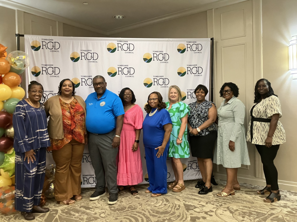 Group photo at the Tombigbee RC&D Annual Meeting, in front of a Tombigbee RC&D Council backdrop.